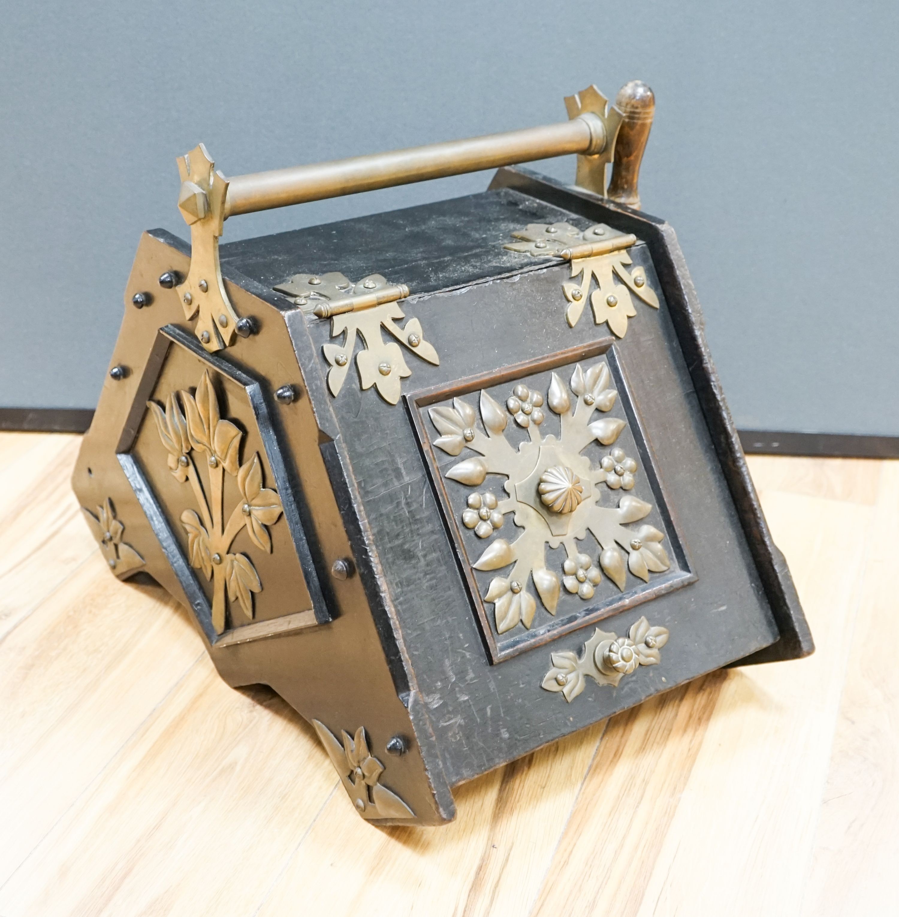 A Victorian Christopher Dresser design brass mounted ebonised coal scuttle, manufactured by Benham & Froud, 40 cm wide